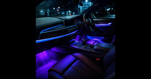 Futuristic luxury car interior at night with RGB LED strip lights glowing purple and blue